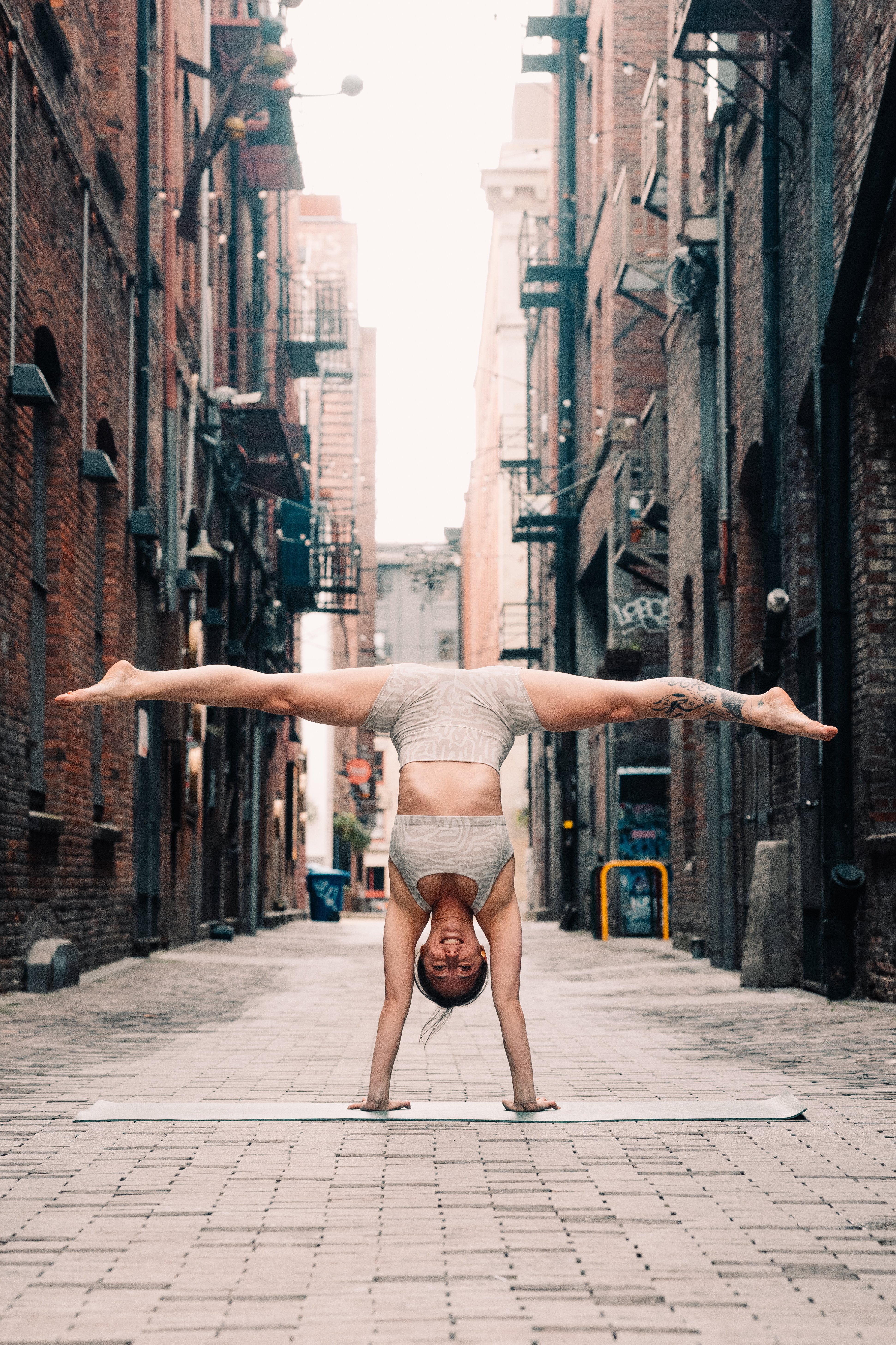 Yoga instructor performing an advanced upside split pose in Pioneer Square, Seattle